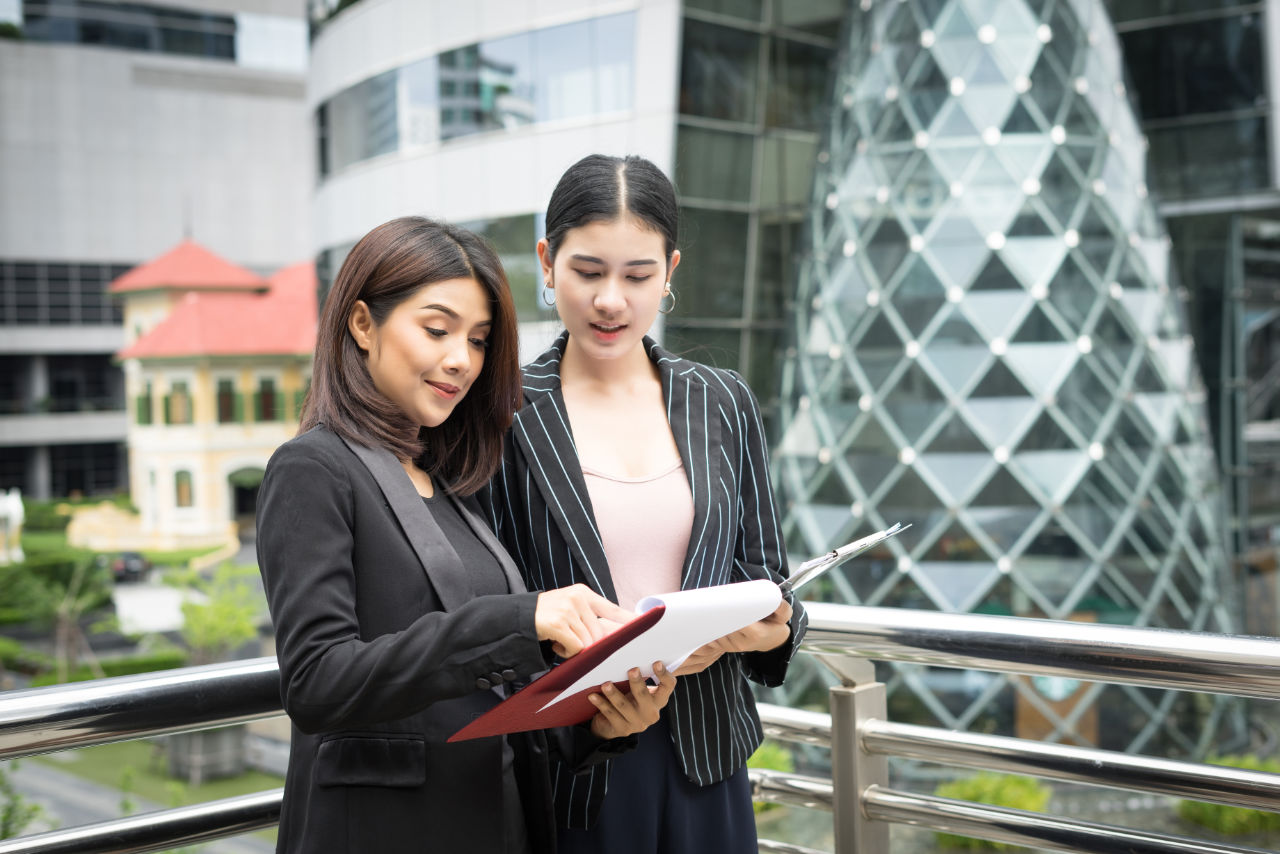 Close up of two Business woman looking with paper document toget